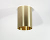 A cylindrical brass downlight fixture with a fixed drum shade head in a down position, showing a sleek metallic finish.