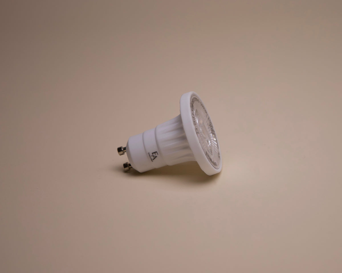 A Long Made Co. Bulb - EmeryAllen MR16 GU10 36° Spread LED dimmable with two prongs lies on its side against a plain beige background.