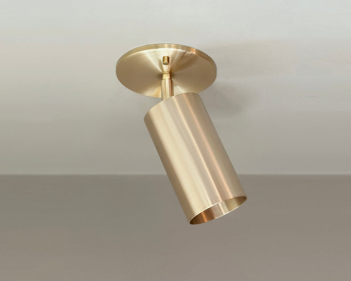 brass ceiling spotlight fixture on a neutral background