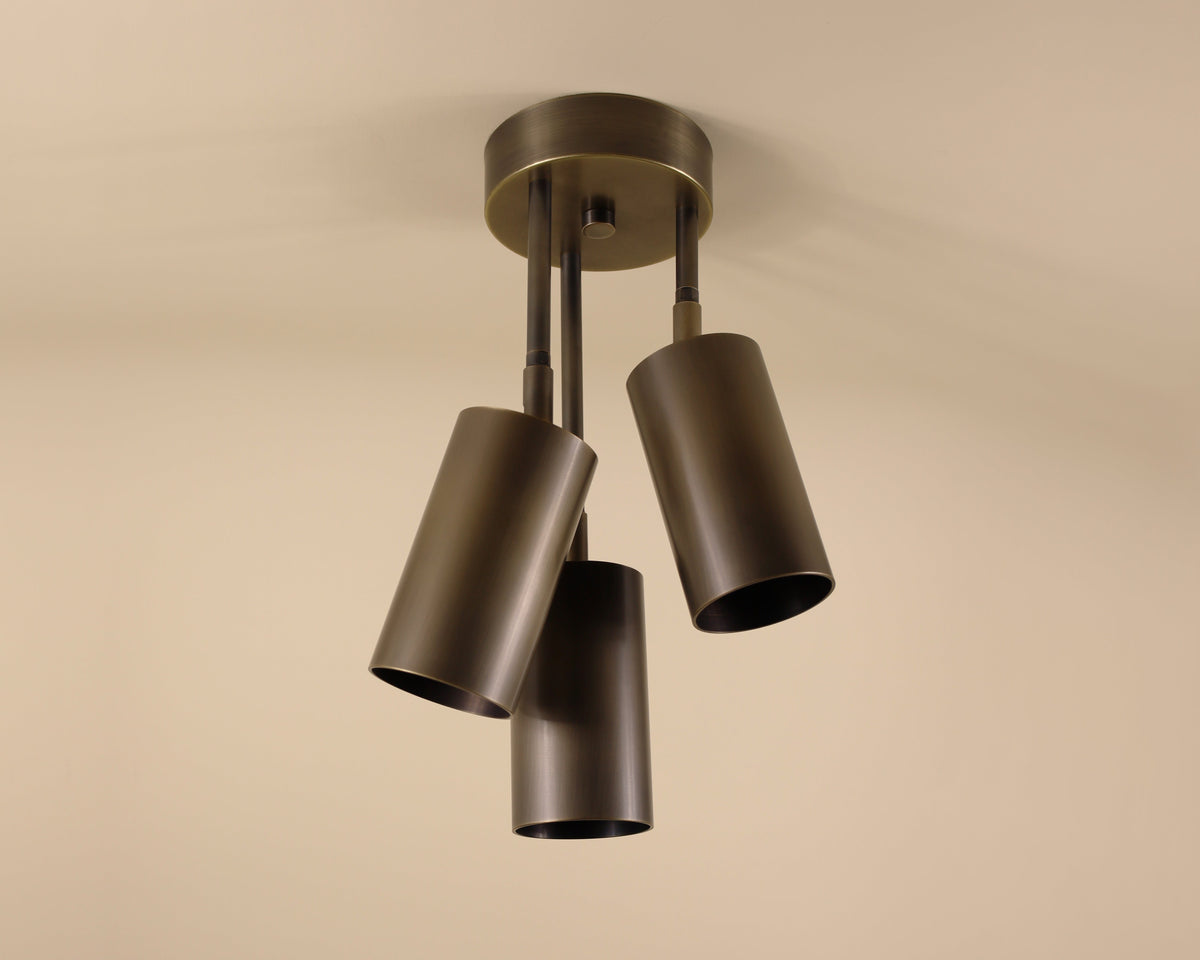 Ceiling light fixture with three cylindrical shades on a beige background