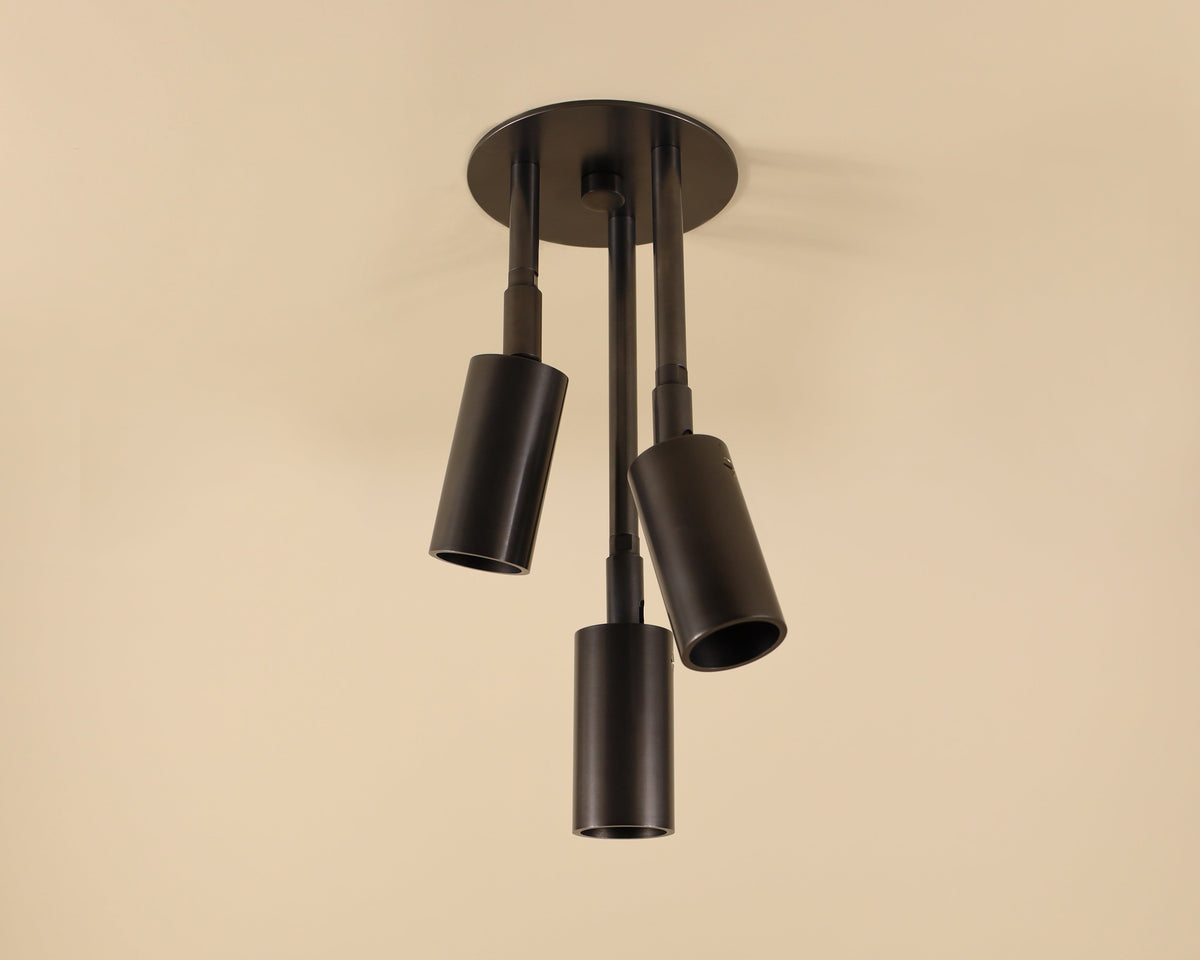 Modern ceiling light fixture with four cylindrical shades on a beige background