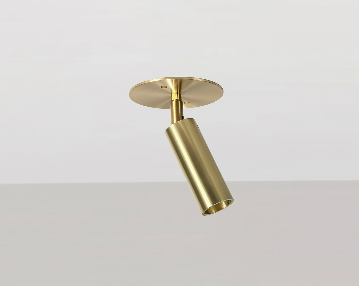 The Micro Adjustable Spot with Long Shade by Long Made Co. is a gold-colored brass flush mount that adds a sleek, modern touch to your space with its minimalist design.