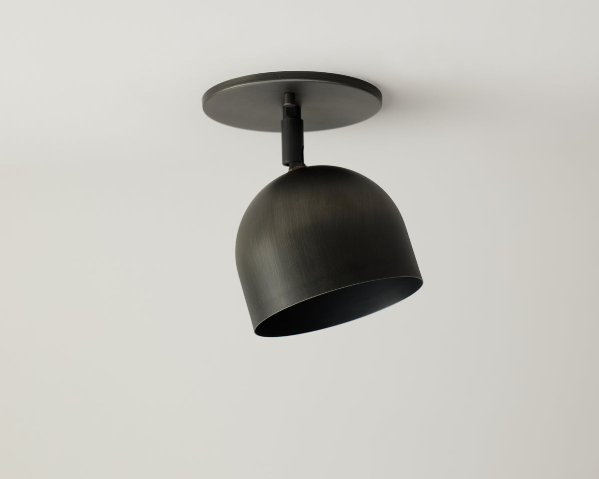 The Monaco Spot by Long Made Co. is a modern black metal dome-shaped downlight ceiling fixture with a matte finish and solid steel construction, mounted on a white ceiling.
