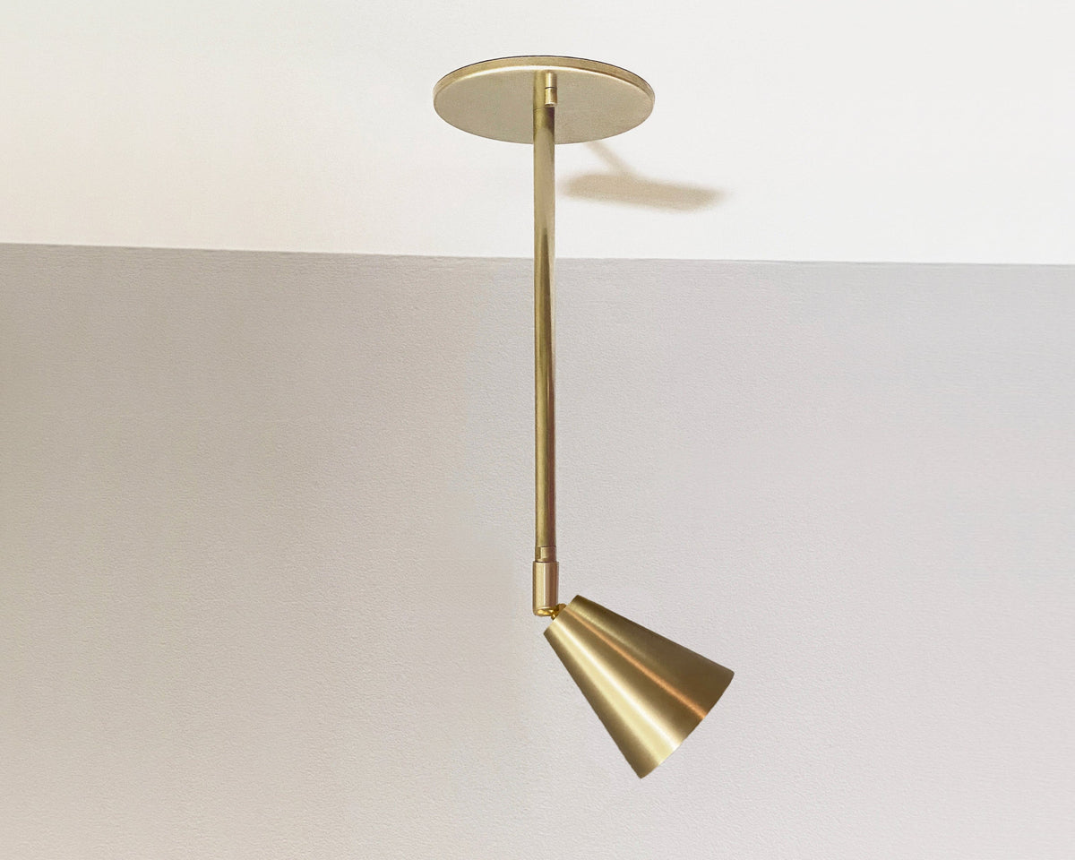 Tiel Drop Spot on ceiling. White ceiling with gray wall background. Adjustable head tilted slightly to angle light. 