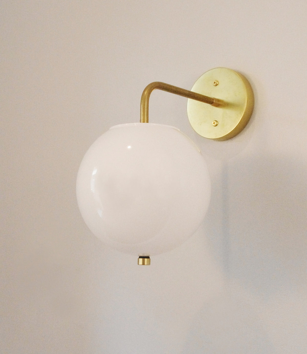 The Wade Wall 8" Globe by Long Made Co. features a sleek acrylic shade, making it a stylish wall sconce that adds modern elegance to any space.
