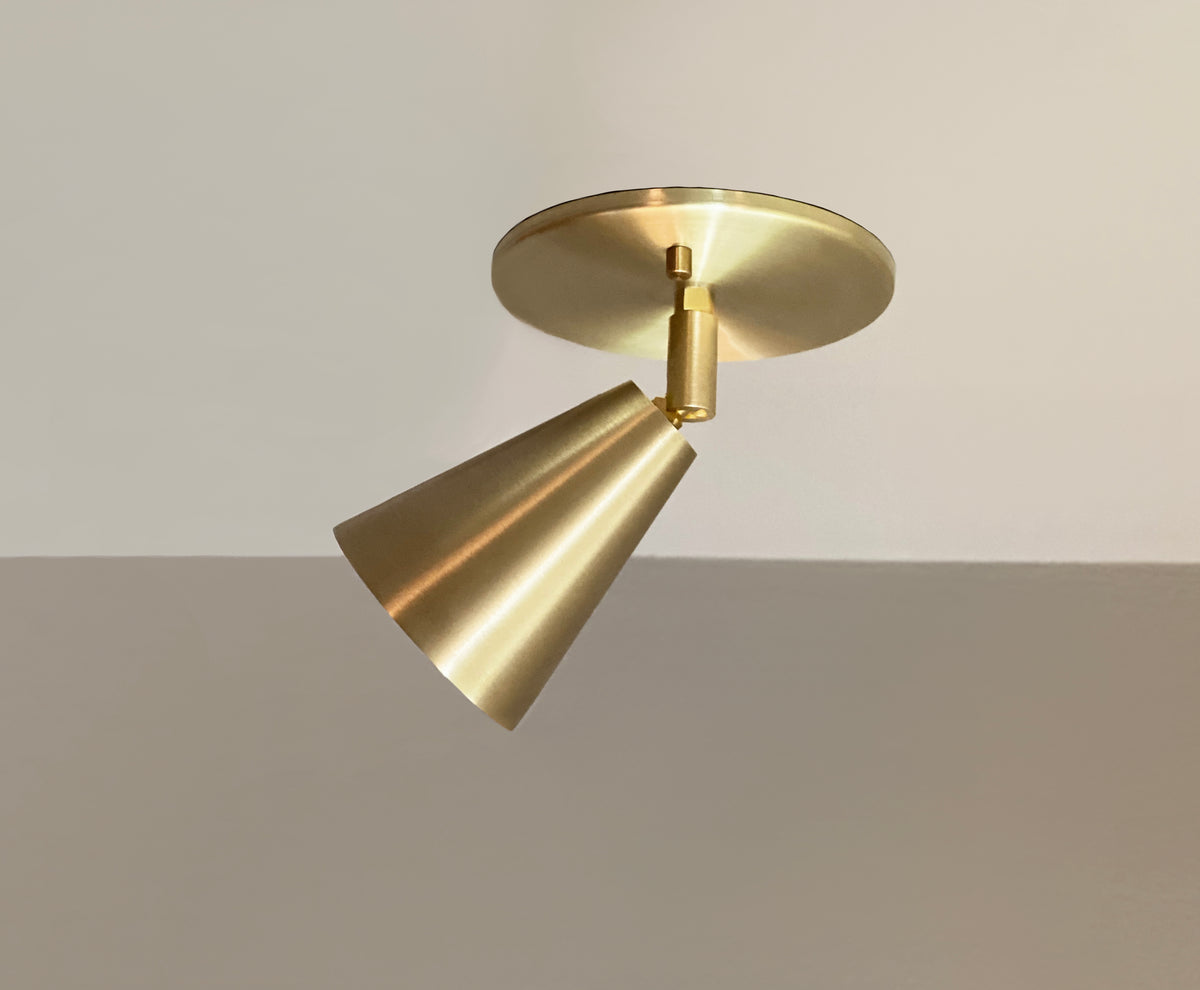 The Tiel Spot - Adjustable by Long Made Co. is a modern solid brass ceiling light with a cone-shaped shade angled downward—an elegant alternative to recessed can lights for neutral ceilings.