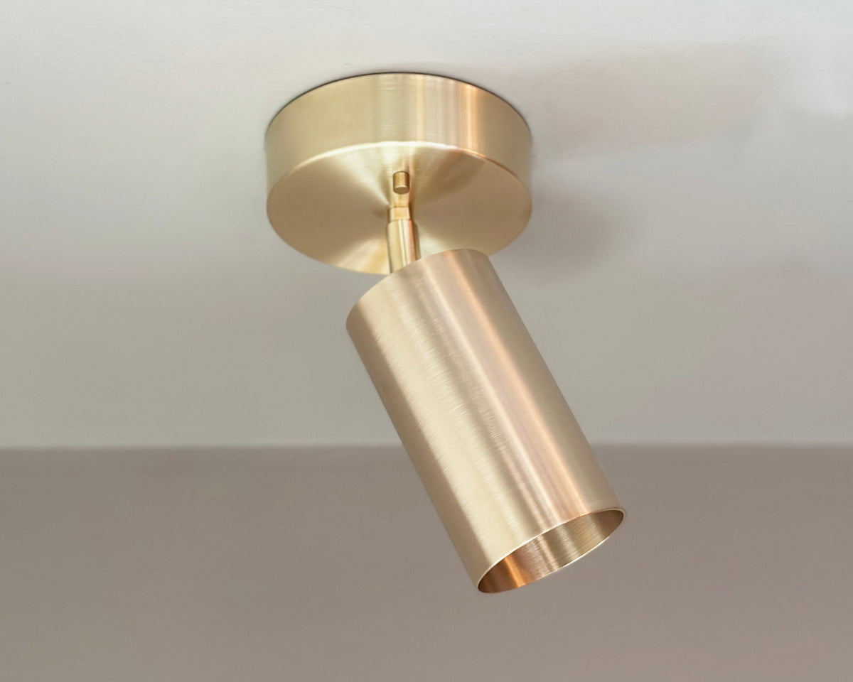The Highland Adjustable Chunky Spot by Long Made Co. is a gold ceiling fixture inspired by minimalist lighting trends, adding a sleek and modern accent to any space.