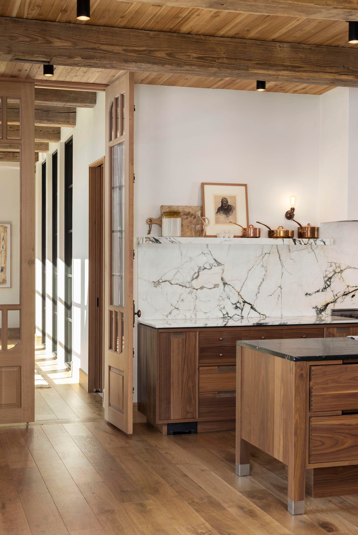 A kitchen with marble countertops and wood cabinets, illuminated by Long Made Co.'s Cove Flush Spot minimalist spotlights for focused task lighting.